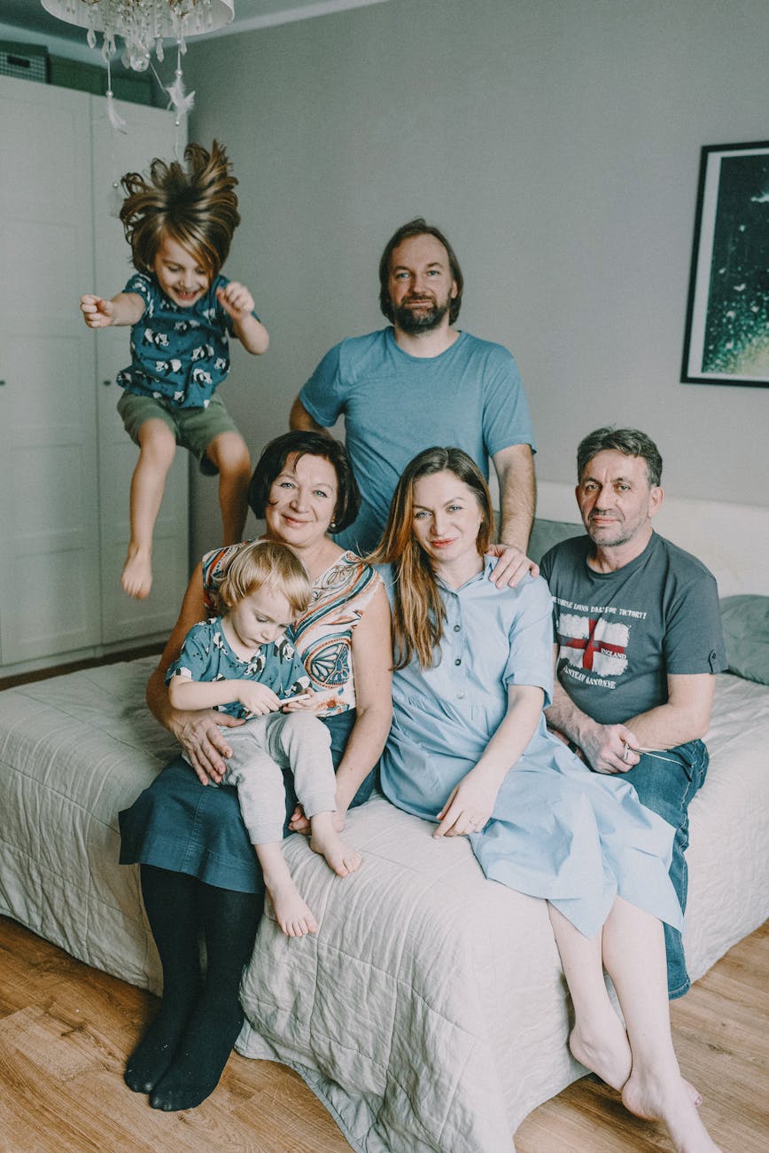 family sitting on bed