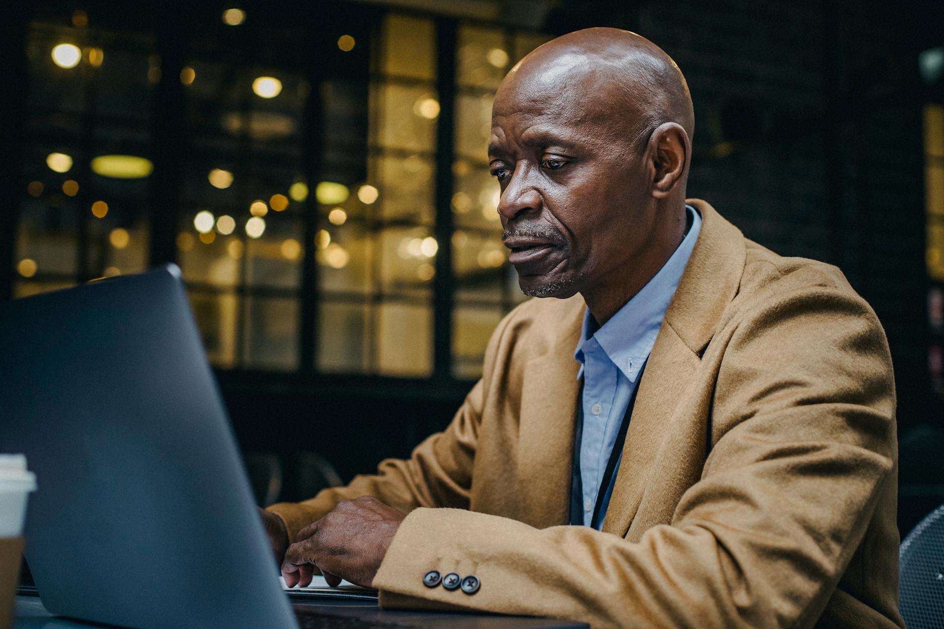 pexels-photo-5648036 concentrated black entrepreneur working on laptop in coffee shop